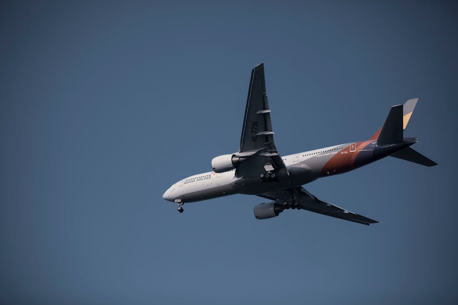 A commercial jet airplane flying against a blue sky, showcasing its sleek design.