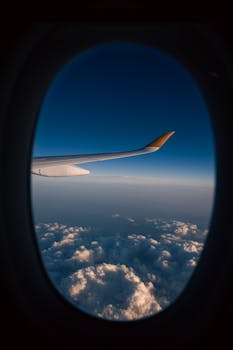 Wing view from airplane with stunning cloudscape at high altitude during flight.